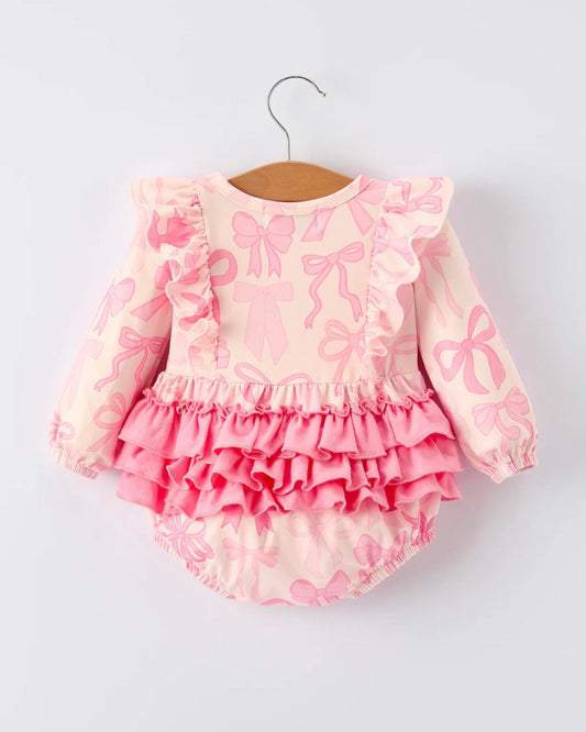 Pink baby romper with ruffles and bow patterns on a white background
