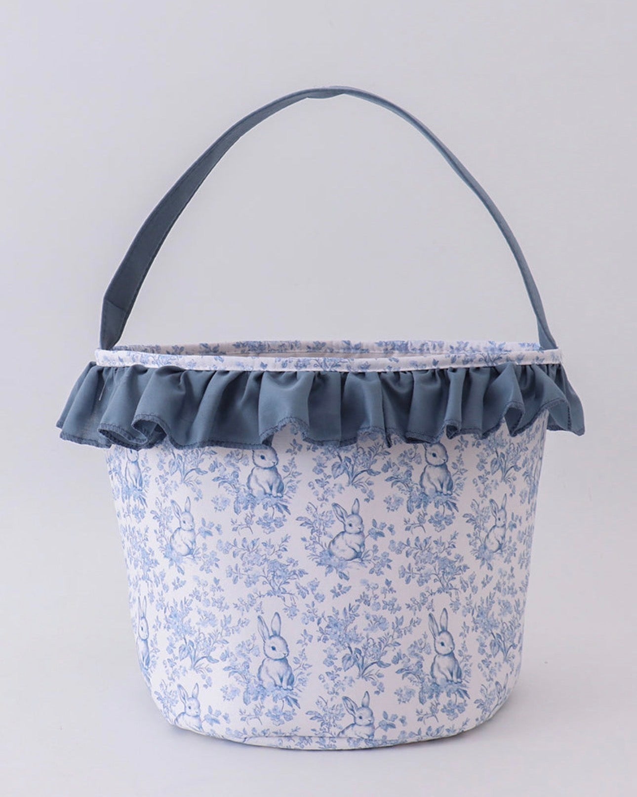 Fabric basket with floral pattern and ruffled edge on a light gray background