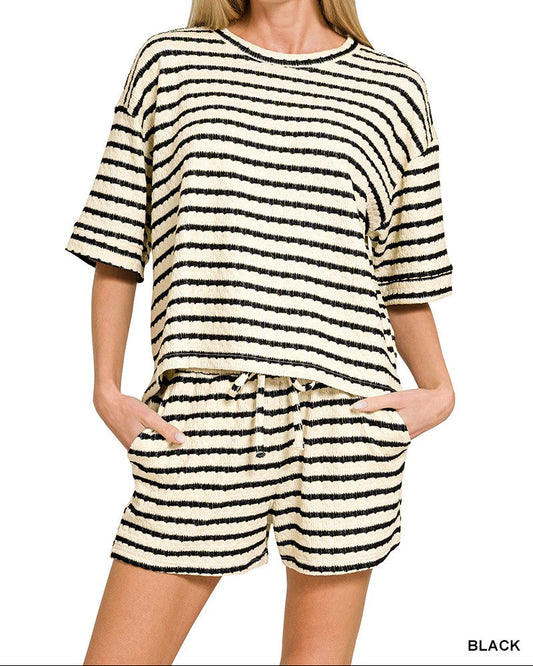 Woman wearing a black and white striped outfit on a plain background