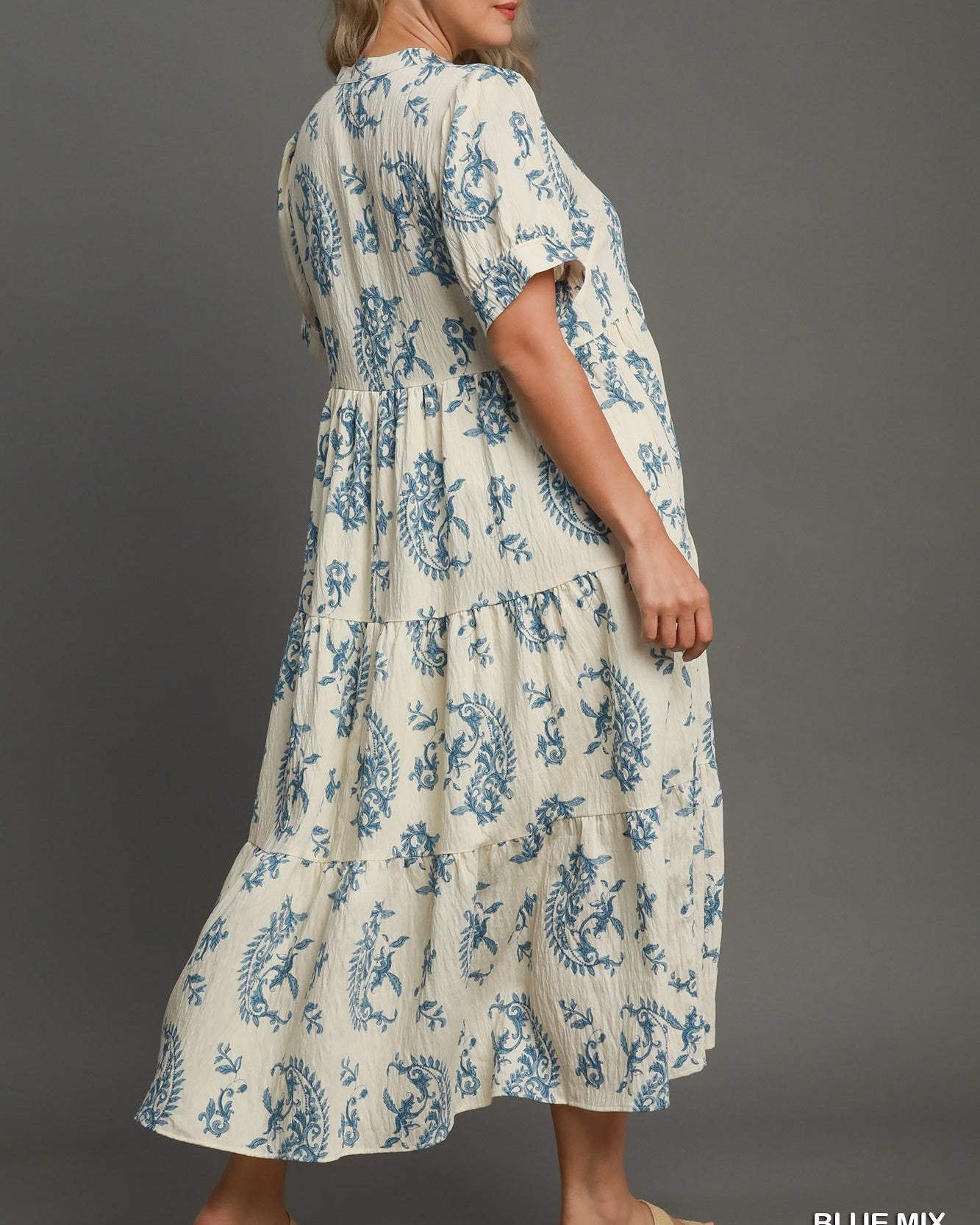 Woman wearing a floral dress with 'Plus Size' and 'Blue Mix' text on a gray background