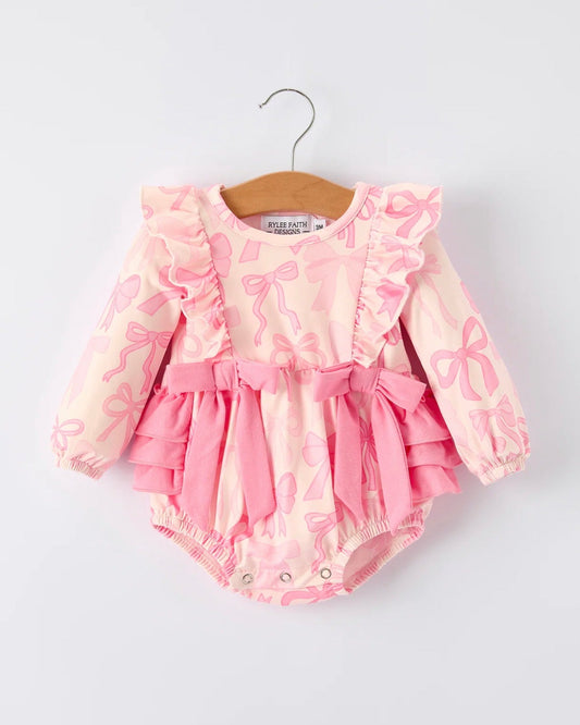 Pink baby romper with ruffles on a hanger against a white background