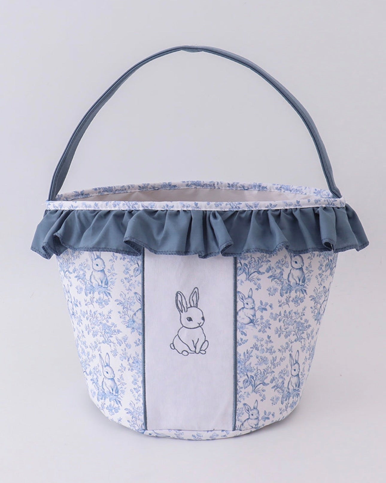 Fabric basket with floral pattern and embroidered bunny design on a white background