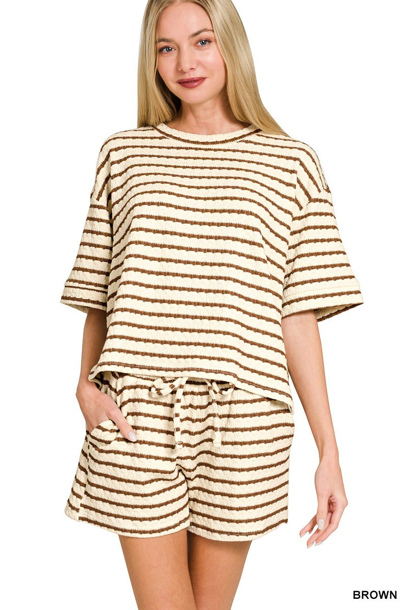 Woman wearing a brown and beige striped outfit on a white background